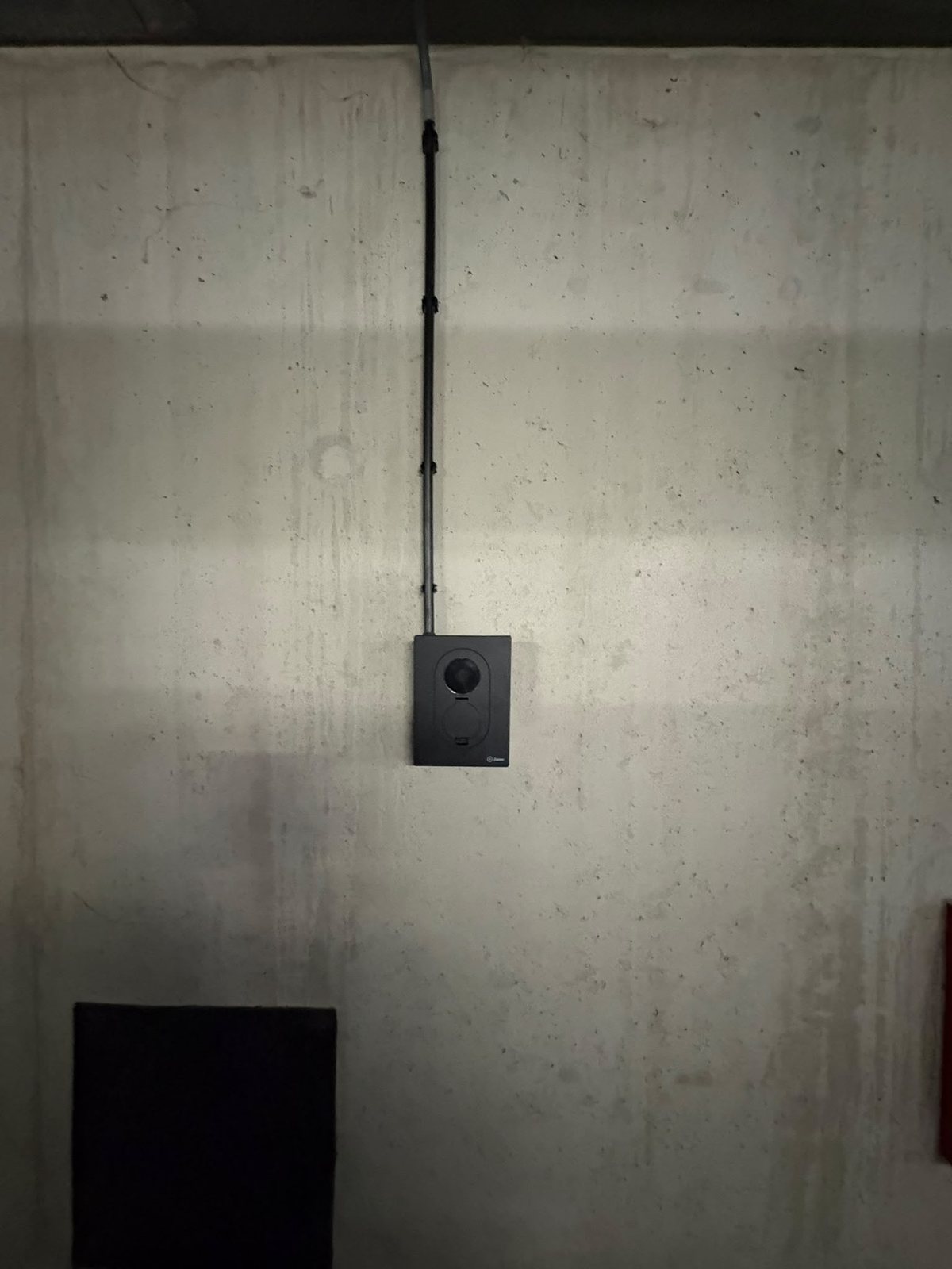 Overzicht van de laadpaal met de kabel recht vanaf het plafond