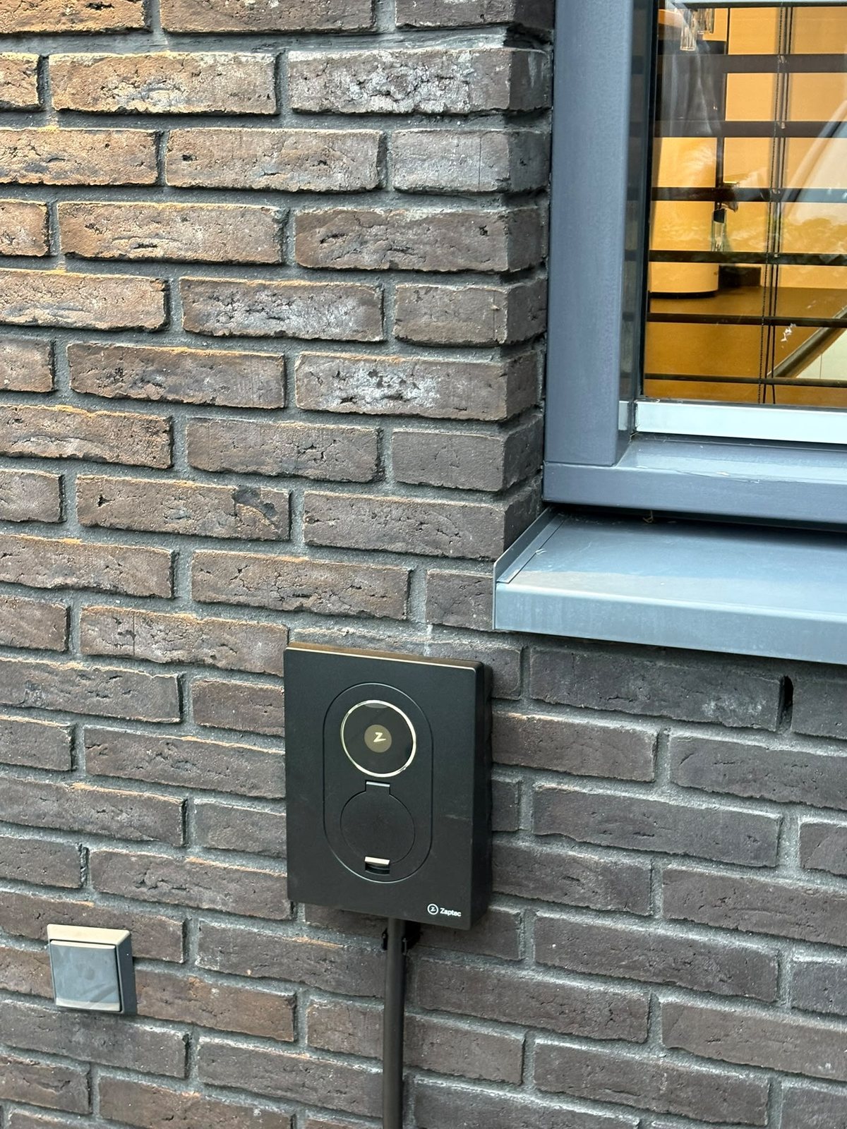Close-up van de Zaptec Go 2 onder het raam